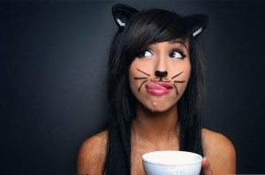 dziewczyna w stroju kota pije mleko